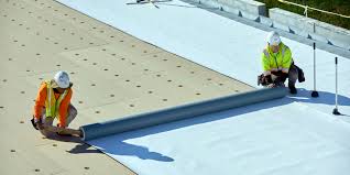 Workers installing PVC roofing membrane