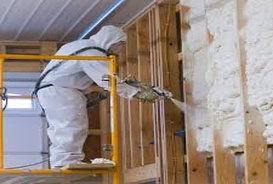 Worker spraying insulation on wall